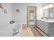 Bright bathroom featuring a garden tub, a door to the patio, and a single vanity with cabinetry at 1439 Waterview Dr, Deltona, FL 32738