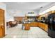 Bright kitchen featuring an island with barstools and a full suite of black appliances at 1439 Waterview Dr, Deltona, FL 32738