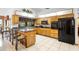 Bright kitchen featuring an island with barstools and a full suite of black appliances at 1439 Waterview Dr, Deltona, FL 32738