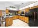 Bright kitchen featuring an island with barstools and a full suite of black appliances at 1439 Waterview Dr, Deltona, FL 32738