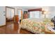 Cozy main bedroom featuring hardwood floors, a floral-patterned bedspread, and a mirrored closet at 1439 Waterview Dr, Deltona, FL 32738
