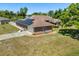 Exterior angle of home with a brown roof, brick facade, solar panels and well manicured landscaping at 1440 Portola Ave, Deltona, FL 32738