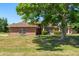 Traditional brick home with arched windows, mature landscaping, and a welcoming red door, shaded by a large tree at 1440 Portola Ave, Deltona, FL 32738
