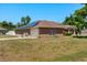 Rear view of brick home with a two car garage and installed solar panels on the roof at 1440 Portola Ave, Deltona, FL 32738