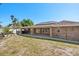 Backyard view of brick house with solar panels, covered patio, and lush greenery at 1440 Portola Ave, Deltona, FL 32738