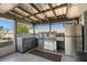 Outdoor kitchen featuring stainless steel appliances and a sink under a covered patio with stylish lighting at 1440 Portola Ave, Deltona, FL 32738