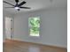 Bright bedroom featuring light-colored walls, wood-look floors and a ceiling fan with light fixture at 1450 Benham Ave, Orange City, FL 32763