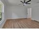 Bright bedroom with wood-look floors, window with wooded view and a ceiling fan with light fixture at 1450 Benham Ave, Orange City, FL 32763