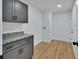 Laundry room featuring wood-look floors, modern gray cabinets with granite countertops and stainless steel hardware at 1450 Benham Ave, Orange City, FL 32763