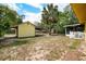 Expansive backyard featuring a yellow shed, mature trees, and ample space for outdoor activities at 1511 Jack St, Tavares, FL 32778