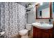 Cozy bathroom with a decorative shower curtain, wooden vanity, and matching framed mirror at 1511 Jack St, Tavares, FL 32778