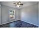 Bedroom featuring wood-look flooring, a ceiling fan, and a single window looking to the exterior at 1511 Jack St, Tavares, FL 32778