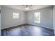 Comfortable bedroom with modern flooring, neutral walls, and natural light from two windows at 1511 Jack St, Tavares, FL 32778