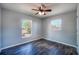 Bedroom featuring wood-look flooring, two windows looking to the exterior, and a ceiling fan at 1511 Jack St, Tavares, FL 32778