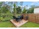 A backyard with a table and chairs set on a wooden platform and fenced in area at 1550 11Th Ave, Deland, FL 32724