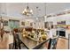 Open-concept dining room with an elegant chandelier, hardwood floors, and a seamless flow into the kitchen and living areas at 1550 11Th Ave, Deland, FL 32724