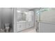 Modern bathroom with double vanity, enclosed glass shower, storage cabinet, and marble tile flooring at 1601 Toledo Ave, Deltona, FL 32725