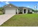 Charming single-story home featuring a well-maintained lawn, a two-car garage, and manicured landscaping at 1601 Toledo Ave, Deltona, FL 32725