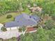 Aerial view of a home with a screened-in pool, attached garage and well-maintained landscaping at 1661 Timber Hills Dr, Deland, FL 32724