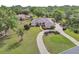 Aerial view of the home showcasing its beautiful landscaping, circular driveway, and lush surroundings at 1661 Timber Hills Dr, Deland, FL 32724