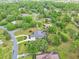 An aerial view of a suburban home with a pool, surrounded by lush trees and verdant landscapes at 1661 Timber Hills Dr, Deland, FL 32724