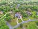 Overhead view of a landscaped home with circular driveway and large manicured lawn in a leafy neighborhood at 1661 Timber Hills Dr, Deland, FL 32724