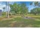 Expansive backyard featuring mature trees, an open lawn, and a cozy fire pit area perfect for outdoor gatherings at 1661 Timber Hills Dr, Deland, FL 32724