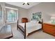 Cozy bedroom with a wooden four-poster bed, window seat, and bright natural light at 1661 Timber Hills Dr, Deland, FL 32724