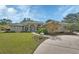 Inviting front exterior showcasing a well-manicured lawn, mature landscaping, and a charming entryway at 1661 Timber Hills Dr, Deland, FL 32724