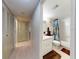 Hallway view of bathroom with tub-shower, vanity, and brown rugs at 168 Perimeter Ct # 5B, Deltona, FL 32725