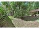 Green backyard with mature trees and a shed, offering space for outdoor activities at 1925 Hamilton Ave, Orange City, FL 32763