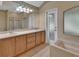 Bathroom featuring double sink vanity, soaking tub, walk-in shower, and a frosted glass window at 1925 Hamilton Ave, Orange City, FL 32763