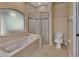 Bathroom boasts a soaking tub, a separate glass-enclosed shower, and neutral tile flooring at 1925 Hamilton Ave, Orange City, FL 32763