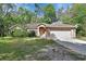 Single-story brick home featuring an attached garage and mature landscaping in a serene setting at 1925 Hamilton Ave, Orange City, FL 32763