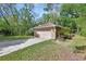 Attached two-car garage featuring a brick exterior and a concrete driveway surrounded by lush greenery at 1925 Hamilton Ave, Orange City, FL 32763