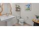 Bathroom with white pedestal sink, toilet, modern decor, and light wood-look tile floor at 199 Verde Way, Debary, FL 32713