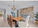 Dining room with a wood table, accent wall, modern chandelier, and tiled floors at 199 Verde Way, Debary, FL 32713