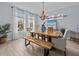 Dining room with wood table, a bench, modern chandelier, and sheer curtains at 199 Verde Way, Debary, FL 32713