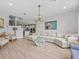 Spacious living room with modern chandelier, coastal decor, light wood floors, and a large comfy sofa at 199 Verde Way, Debary, FL 32713