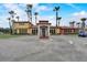 Exterior view of the clubhouse with vibrant colors, tall palms, a fountain, and a circular driveway at 199 Verde Way, Debary, FL 32713