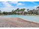Spacious community pool area with plenty of lounge chairs and palm trees for relaxing in the sun at 199 Verde Way, Debary, FL 32713