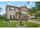 Two-story home with a red tile roof and brown shutters, complemented by a landscaped yard and a brick driveway at 199 Verde Way, Debary, FL 32713