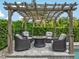Inviting outdoor seating area featuring a pergola and comfortable wicker chairs around a cozy fire pit at 199 Verde Way, Debary, FL 32713