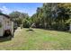 Grassy backyard offers ample space for recreation and gardening, with mature trees providing shade at 219 Brevity Ln, Deland, FL 32724