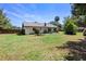 Well-maintained backyard showcasing a lush lawn, mature trees, and a patio area for outdoor entertainment at 219 Brevity Ln, Deland, FL 32724