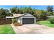 Front exterior with a two-car garage, complemented by colorful landscaping and a brick-paved driveway at 219 Brevity Ln, Deland, FL 32724