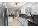 Well-lit kitchen with black marble countertops, white cabinets, blue tile backsplash, and stainless steel appliances at 219 Brevity Ln, Deland, FL 32724