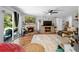 Welcoming living room featuring hardwood floors, stone fireplace, a ceiling fan, and sliding glass doors at 219 Brevity Ln, Deland, FL 32724