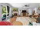 Cozy living room with a stone fireplace, hardwood floors, and a sliding glass door to the backyard at 219 Brevity Ln, Deland, FL 32724
