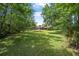 Large backyard surrounded by tall mature trees with a manicured lawn at 229 Riverbend Rd, Ormond Beach, FL 32174